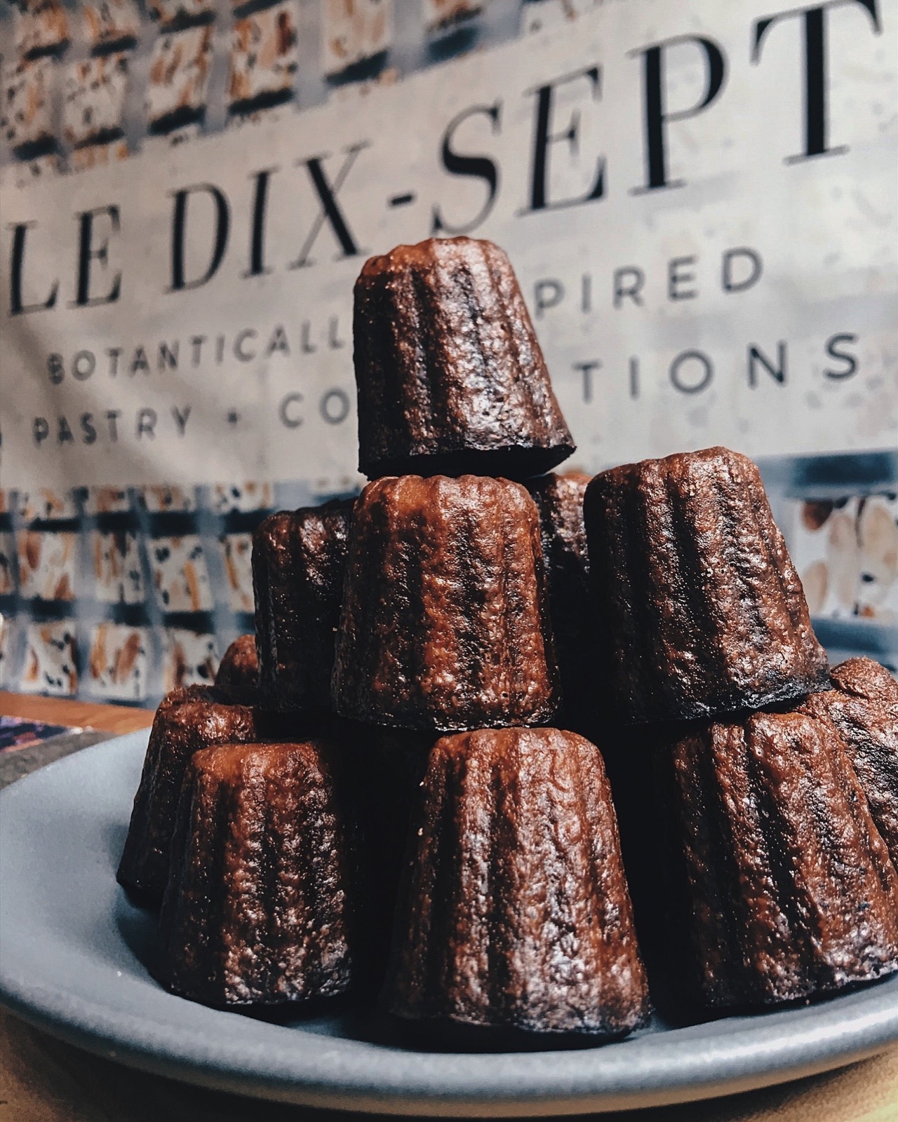 Stacked caramelized cannelés on a plate at Le Dix-Sept