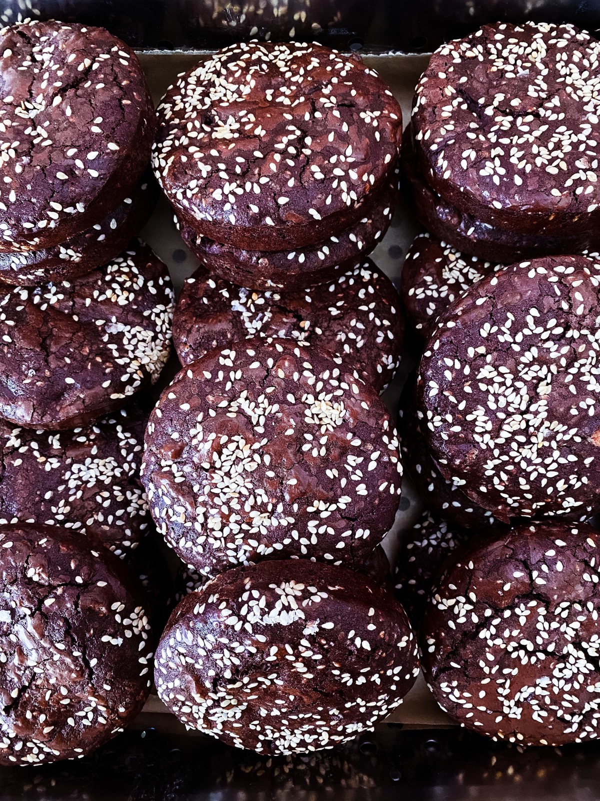 Tray of dark buckwheat brownie cookies dusted with sesame