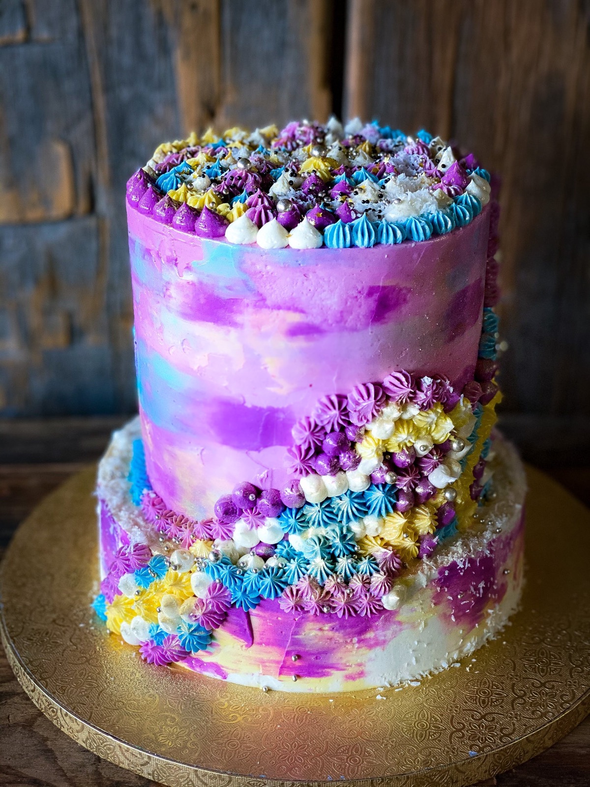 Two-tier botanical celebration cake by Le Dix-Sept, hand-piped buttercream in watercolor tones
